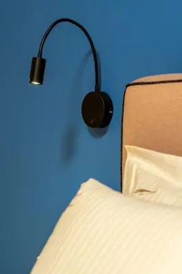 a black lamp next to a bed with a pillow at Piraeus Marina Haven 1 in Piraeus