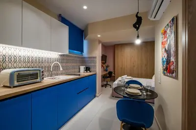 a kitchen with blue cabinets and a table with blue chairs at Piraeus Marina Haven 1 in Piraeus