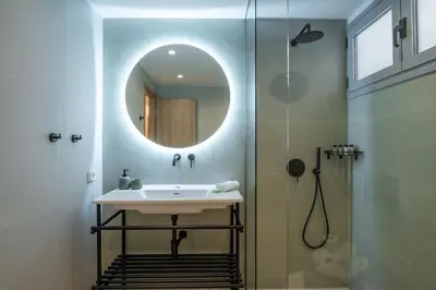 a bathroom with a sink and a shower with a mirror at Piraeus Marina Haven 3 in Piraeus