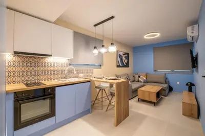 a kitchen and living room with a couch and a table at Multi-Unit Apartment Piraeus - For Large Groups in Piraeus