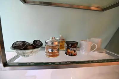 a glass shelf with jars and a bowl of food at Warm & cozy studio - apartment 1 in Athens