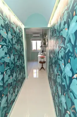 a hallway with a mural of leaves on the wall at Warm & cozy studio - apartment 1 in Athens