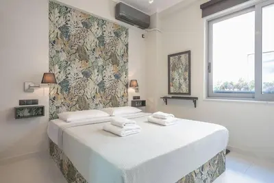 a white bedroom with a large bed with towels on it at Warm & cozy studio - apartment! #9 in Athens