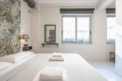 a white bedroom with a large bed with two towels on it at Warm & cozy studio - apartment! #9 in Athens