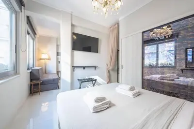 a white bedroom with a bed with towels on it at Warm & cozy studio - apartment! #9 in Athens