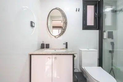 a bathroom with a sink and a mirror and a toilet at Warm & cozy studio - apartment! #9 in Athens