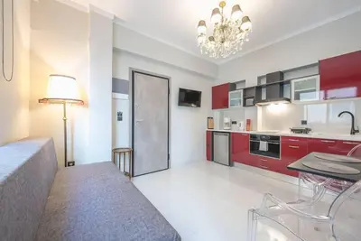 a kitchen with red cabinets and a table in a room at Warm & cozy studio - apartment! #9 in Athens