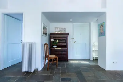 a hallway with a radiator and a wooden chair at Danae's Art in Athens