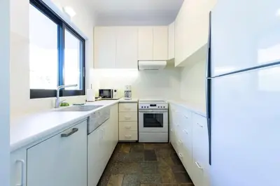 a kitchen with white cabinets and a refrigerator at Danae's Art in Athens