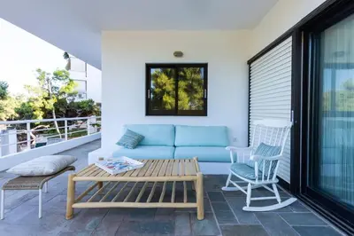 a blue couch and two chairs on a balcony at Danae's Art in Athens