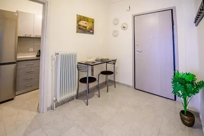 a kitchen with a table and two chairs and a door at Ser House in Athens