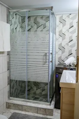 a shower with a glass door in a bathroom at Ser House in Athens