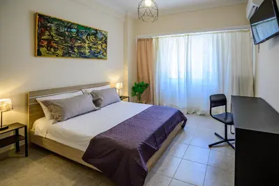 a bedroom with a bed and a desk and a window at Ser House in Athens