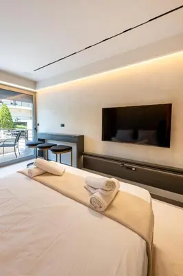 a bedroom with a large bed and a flat screen tv at Fiftyone Deluxe Studio in Athens
