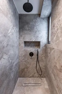 a bathroom with a shower with a stone wall at Fiftyone Deluxe Studio in Athens