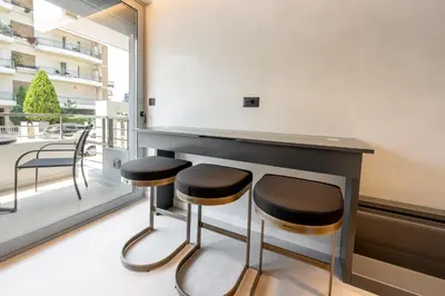 a bar with two stools next to a window at Fiftyone Deluxe Studio in Athens