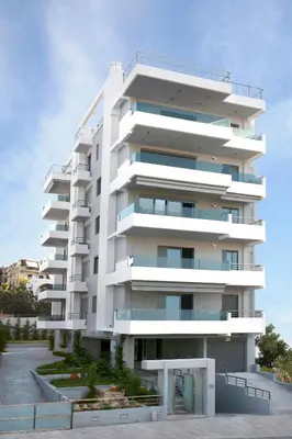 a tall white apartment building with a parking lot at Fiftyone Deluxe Studio in Athens