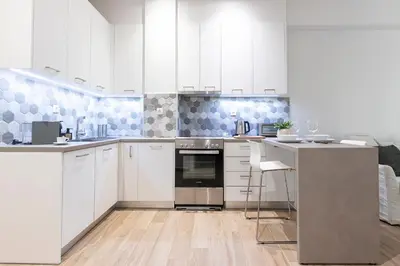 a kitchen with white cabinets and stainless steel appliances at Zeus 1 bdr apartment in Koukaki in Athens