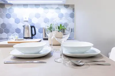a table with plates and wine glasses on it at Zeus 1 bdr apartment in Koukaki in Athens