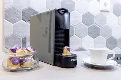 a coffee maker and a bowl of cookies and a cup at Zeus 1 bdr apartment in Koukaki in Athens