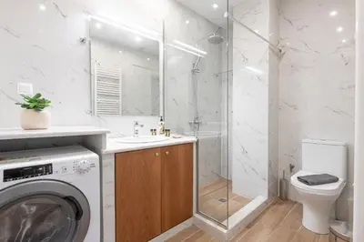 a bathroom with a washing machine and a shower at Zeus 1 bdr apartment in Koukaki in Athens