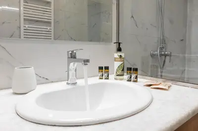 a white sink in a bathroom with a shower at Zeus 1 bdr apartment in Koukaki in Athens