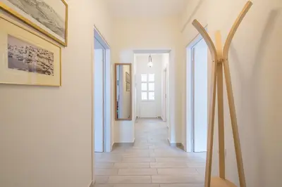a hallway with white walls and white floors and paintings at Petralona Gem with Private Terrace in Athens