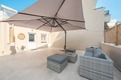 a patio with a large umbrella and a couch and stool at Petralona Gem with Private Terrace in Athens
