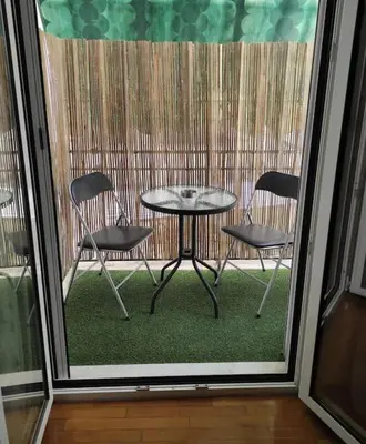 a patio with a table and chairs on a balcony at Alexandra 's Home in Athens