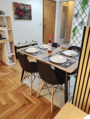 a table with glasses and a bottle of wine on it at Alexandra 's Home in Athens