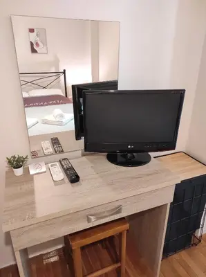 a desk with a television on top of it at Alexandra 's Home in Athens