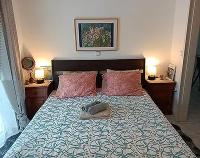 a bed with two pillows and a purse on it at Artemis sea house in Porto Rafti