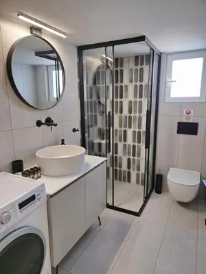 a bathroom with a shower and a sink and a toilet at Tranquil 2BR Penthouse Petralona in Athens
