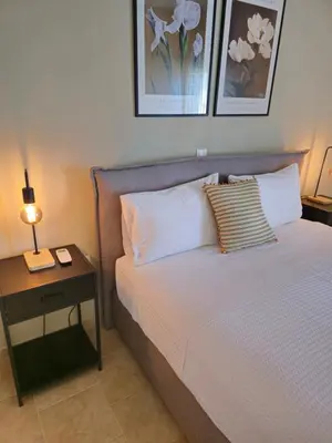 a bedroom with a bed and a table with a lamp at Tranquil 2BR Penthouse Petralona in Athens