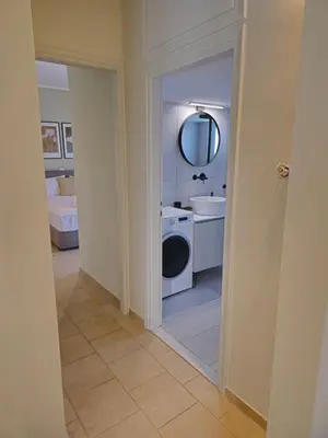 a bathroom with a sink and a washing machine at Tranquil 2BR Penthouse Petralona in Athens