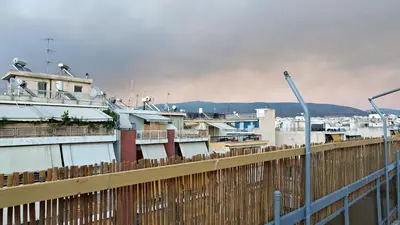 a fence in front of a city with buildings at 1\u53f7\u6c11\u5bbf in Athens