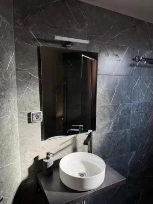 a bathroom with a sink and a mirror at FlyHome Apartments near the Airport in Spáta