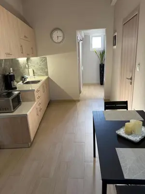 a kitchen and dining room with a table and a counter top at FlyHome Apartments near the Airport in Spáta