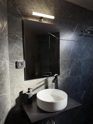 a bathroom with a white sink and a mirror at FlyHome Apartments near the Airport in Spáta