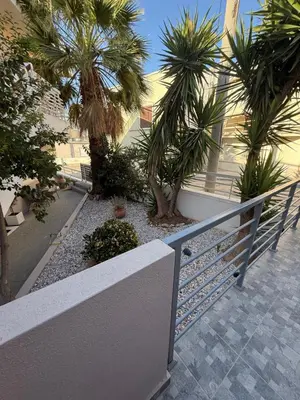 a balcony with palm trees in front of a building at FlyHome Apartments near the Airport in Spáta