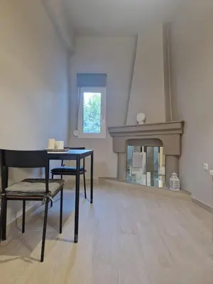 a living room with a table and a fireplace at FlyHome Apartments near the Airport in Spáta