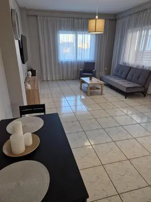 a living room with a couch and a table at FlyHome Apartments near the Airport in Spáta