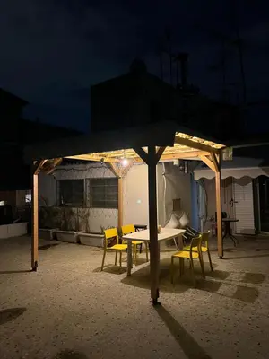 a table and chairs under a pavilion at night at For big family in Athens