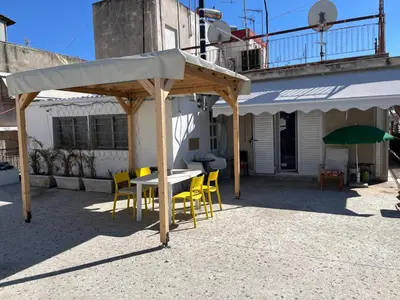 a table and chairs under a canopy on a patio at For big family in Athens
