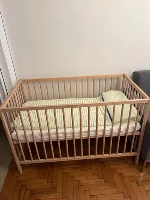 a wooden crib sitting on top of a wooden floor at For big family in Athens