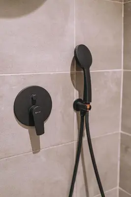 a shower head on a wall in a bathroom at Modern Urban Oasis with Private Plunge Pool in Piraeus
