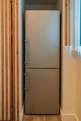 a white refrigerator in a room with a wall at Modern Urban Oasis with Private Plunge Pool in Piraeus