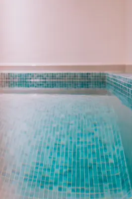 a swimming pool with blue tiles on it at Modern Urban Oasis with Private Plunge Pool in Piraeus