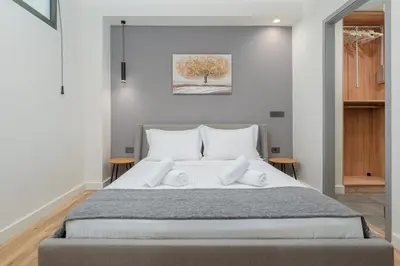 a bedroom with a large bed with white pillows at Modern Urban Oasis with Private Plunge Pool in Piraeus