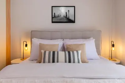 a bedroom with a white bed with two lamps at Phaedrus Living Moschato City Flat in Piraeus